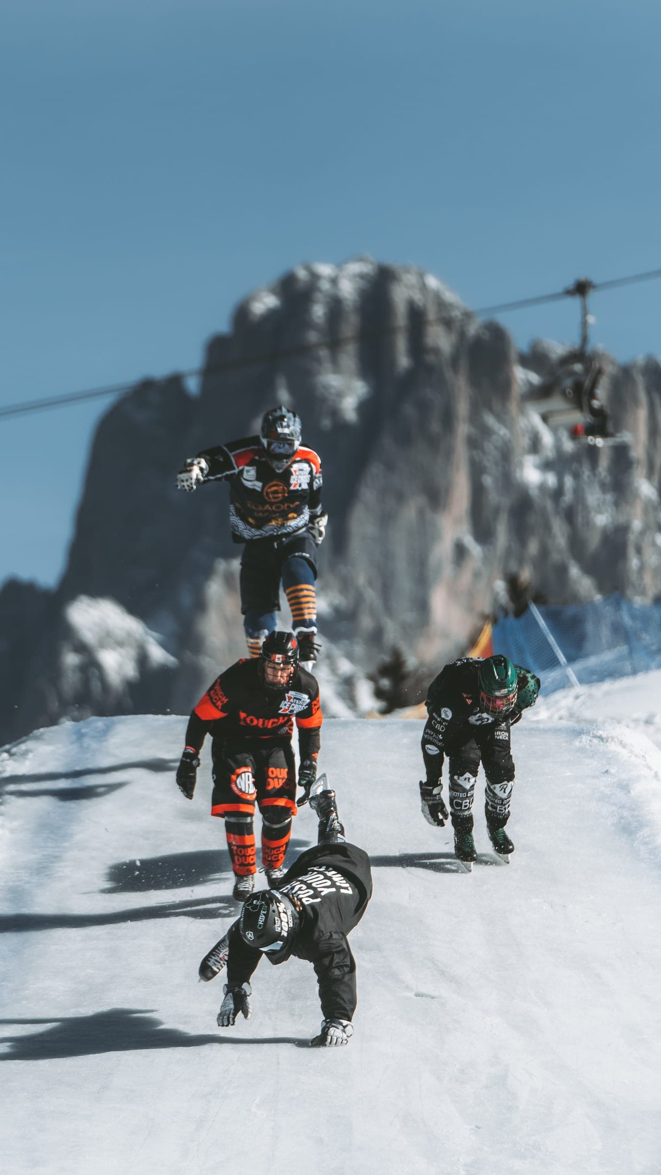 Athletes skating downhill on an ice cross course